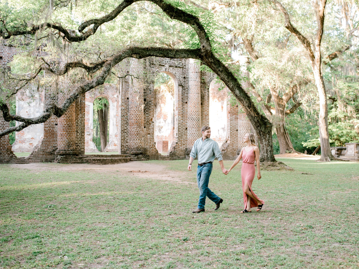 Couple walking with church ruins in background