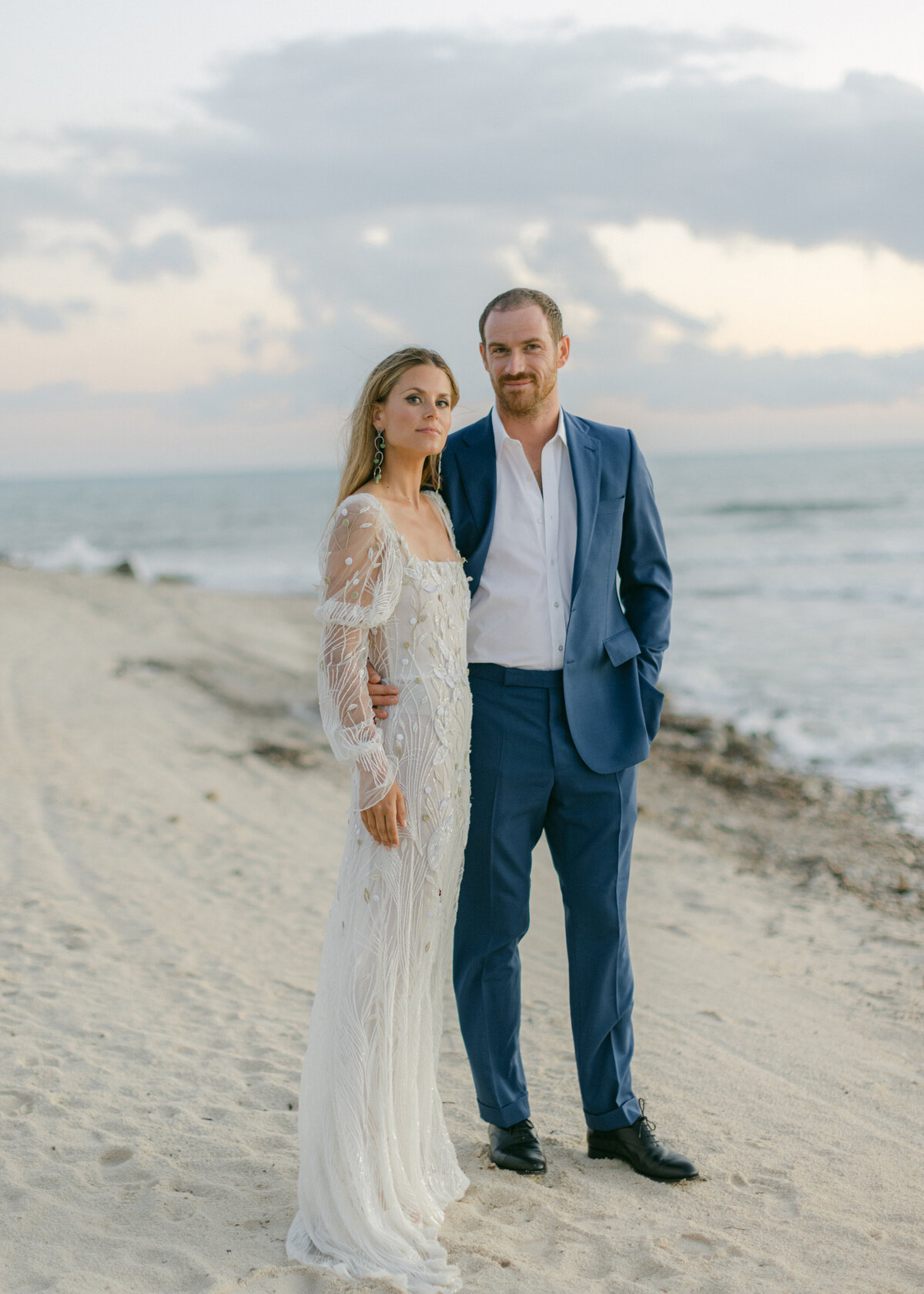 Bride and groom smiling near water.