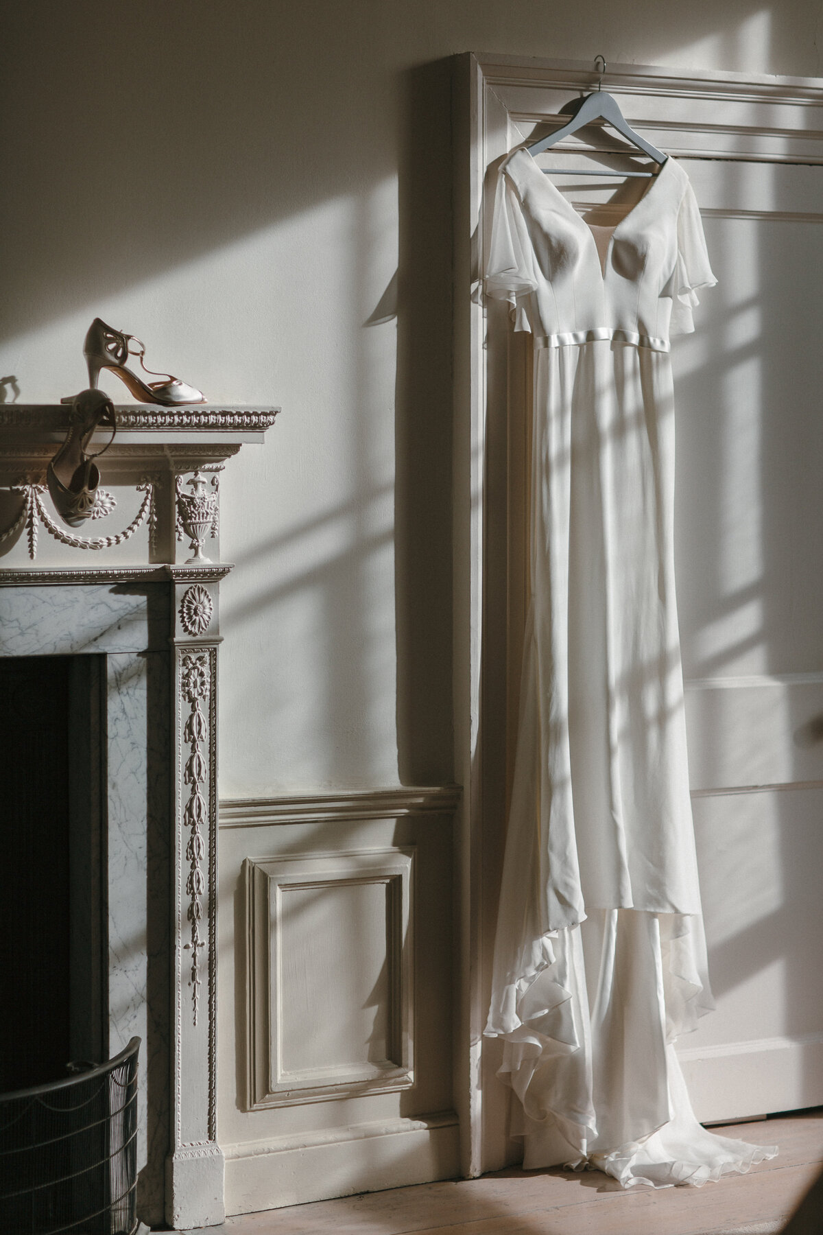 Wedding Dress hanging in low sunlight at wedding venue Pynes House in Deovn