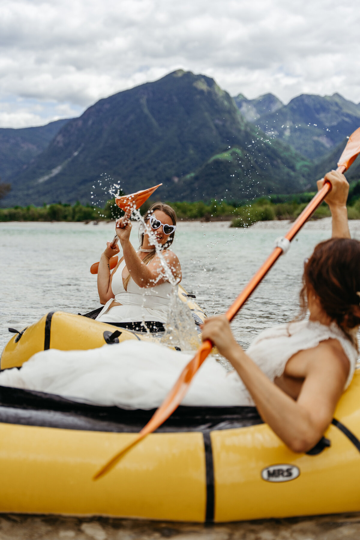 romantic couple in wedding dresses kayaking Soča River