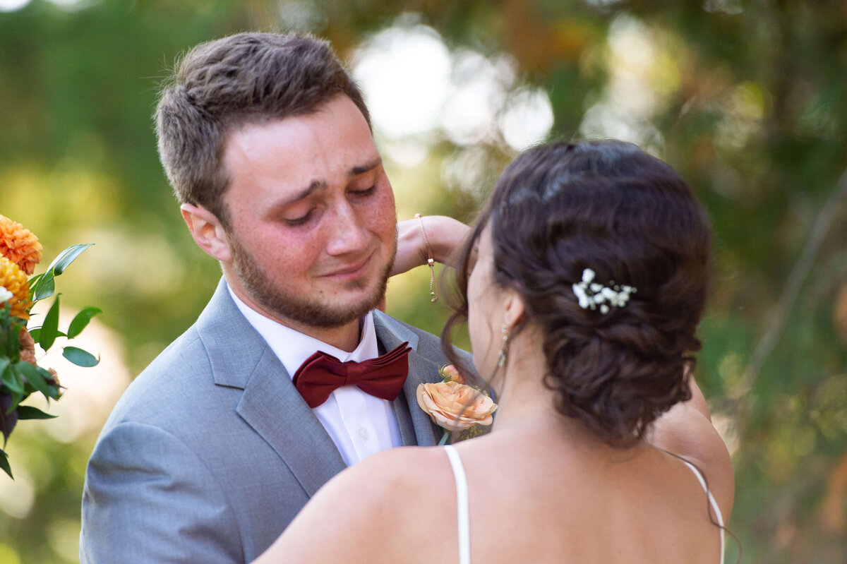 groom crying as he sees his bride for the first time taken outside in the gardens at Strathmere wedding venue.   Captured by Ottawa wedding photographer JEMMAN Photography