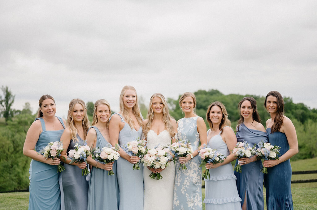 Bride and bridesmaids portrait with a dress of light blue to dark blue dresses