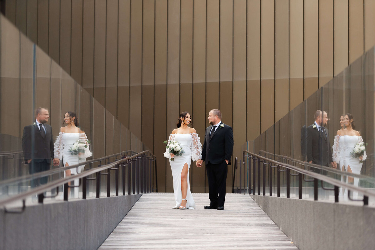 a bride and groom standing holding hands outside the NAC venue taken by Ottawa wedding photographer JEMMAN Photography