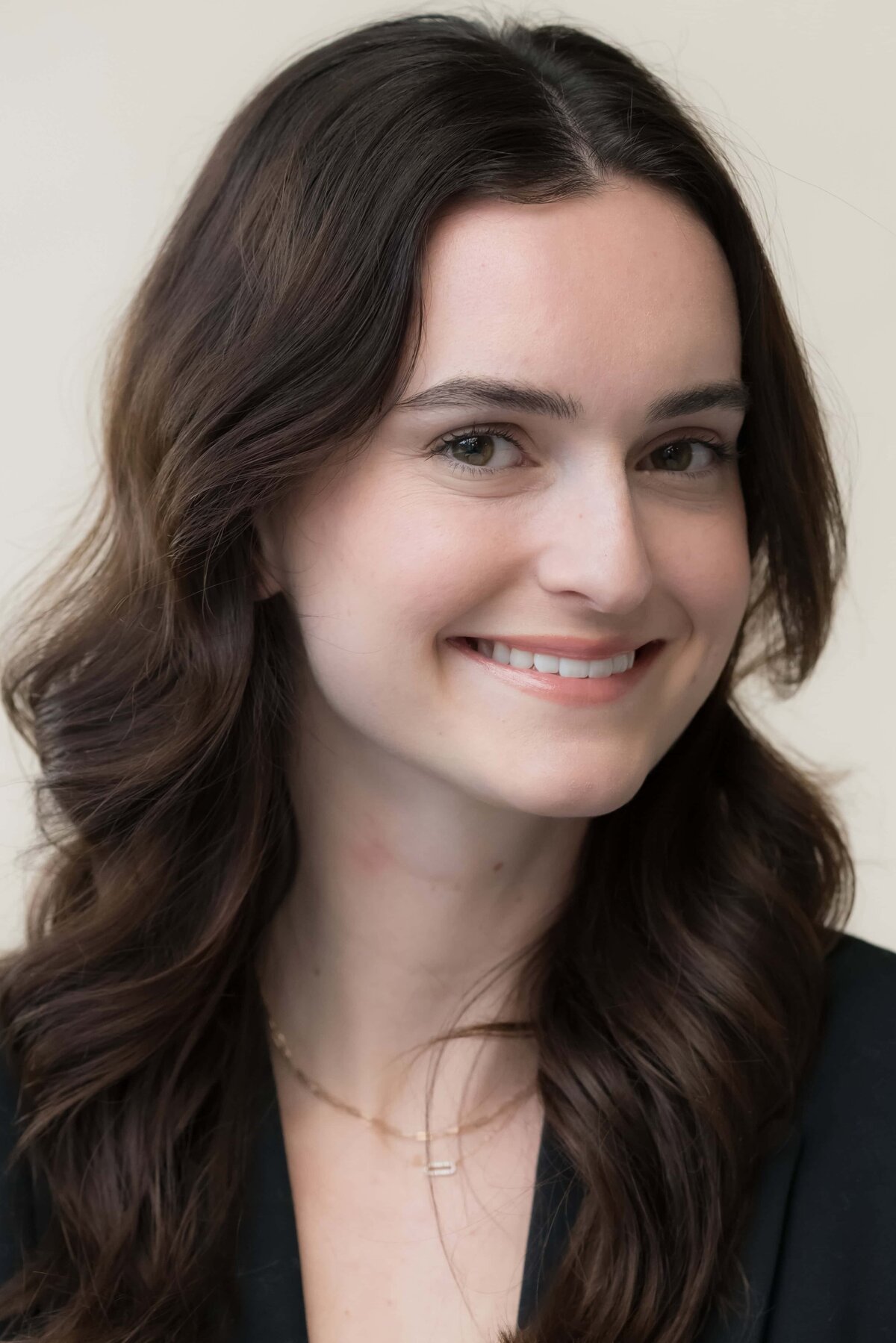Close-up headshot of a young woman with long dark hair smiling 