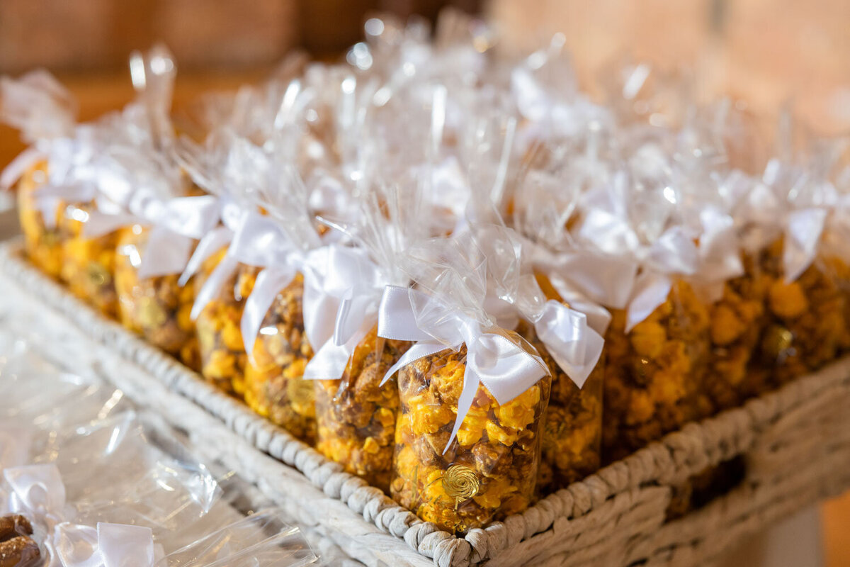 A basket filled with bags of popcorn with bows on them