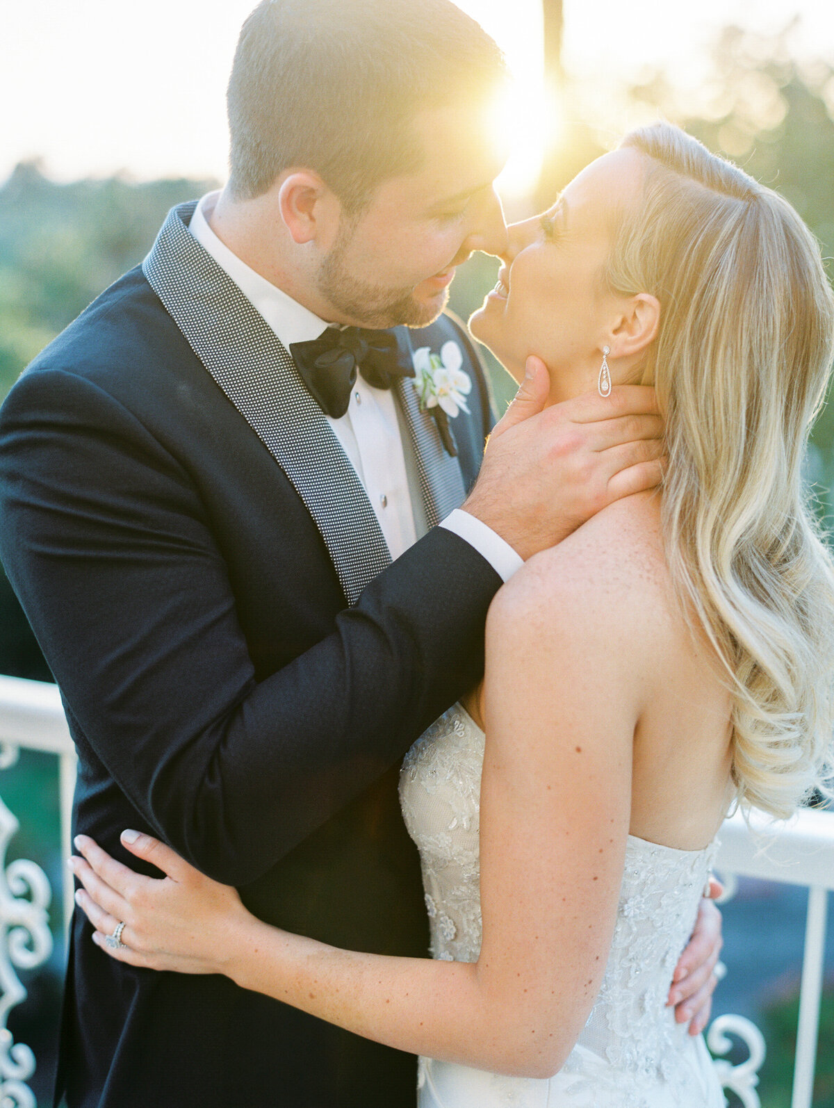 A couple sharing an intimate kiss at sunset, beautifully captured in San Francisco wedding photography. The warm golden light of the setting sun highlights their love, with the iconic San Francisco skyline or landscape creating the perfect backdrop for this romantic moment