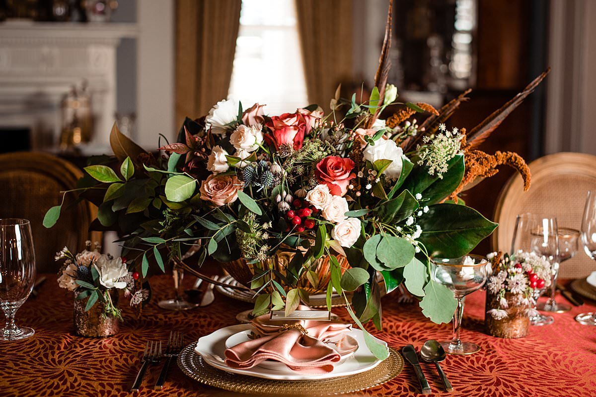 Autumn themed large floral centerpiece with velvet table cloth  and gold place settings