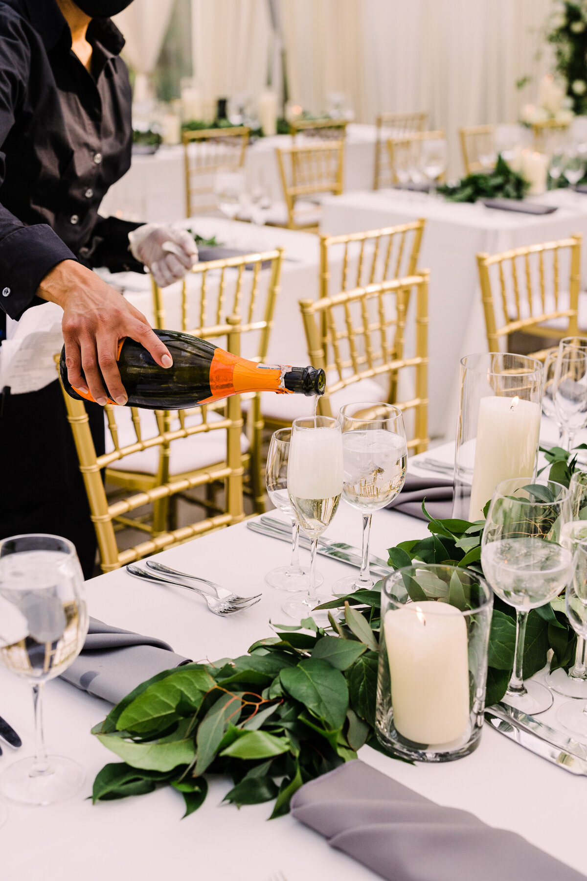 A celebratory close-up of champagne being poured into a glass at a wedding reception.