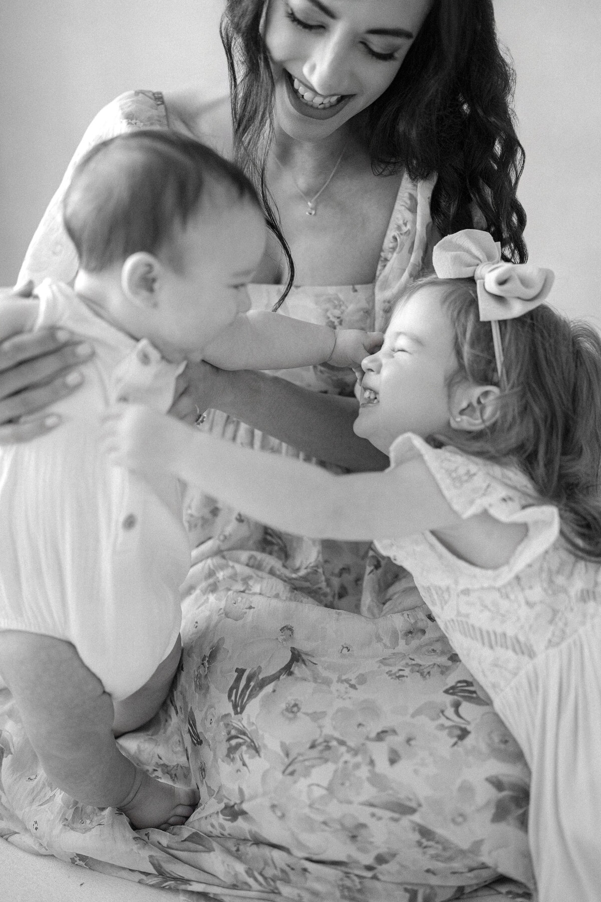 Tampa 6-month milestone portrait of smiling baby boy, big sister and mother in natural light studio