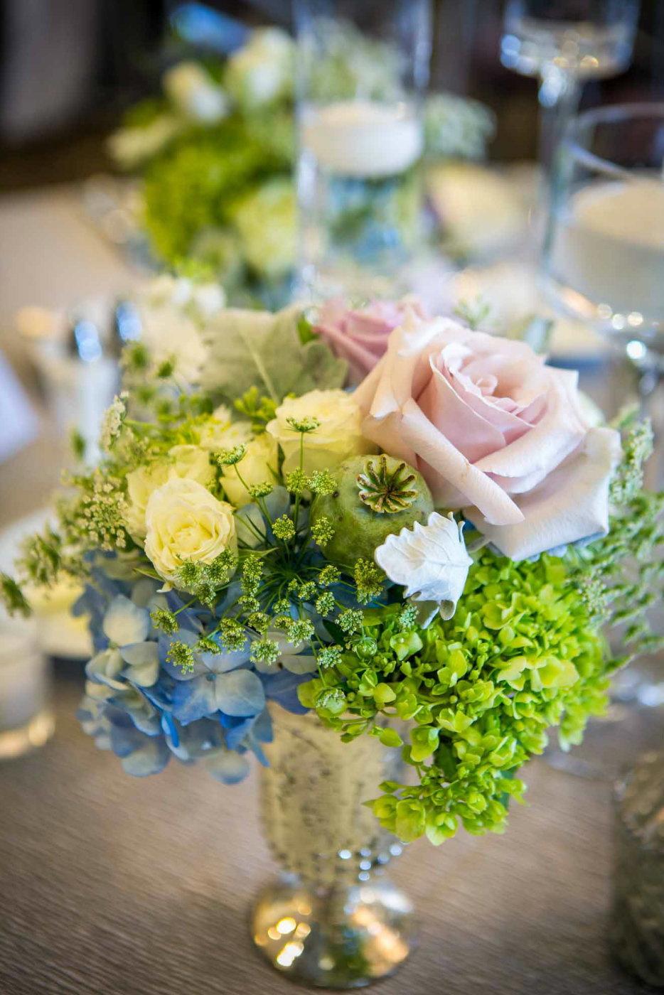 silver compote arrangement with blush rose, green hydrangea, poppy pod,, blue hydrangea