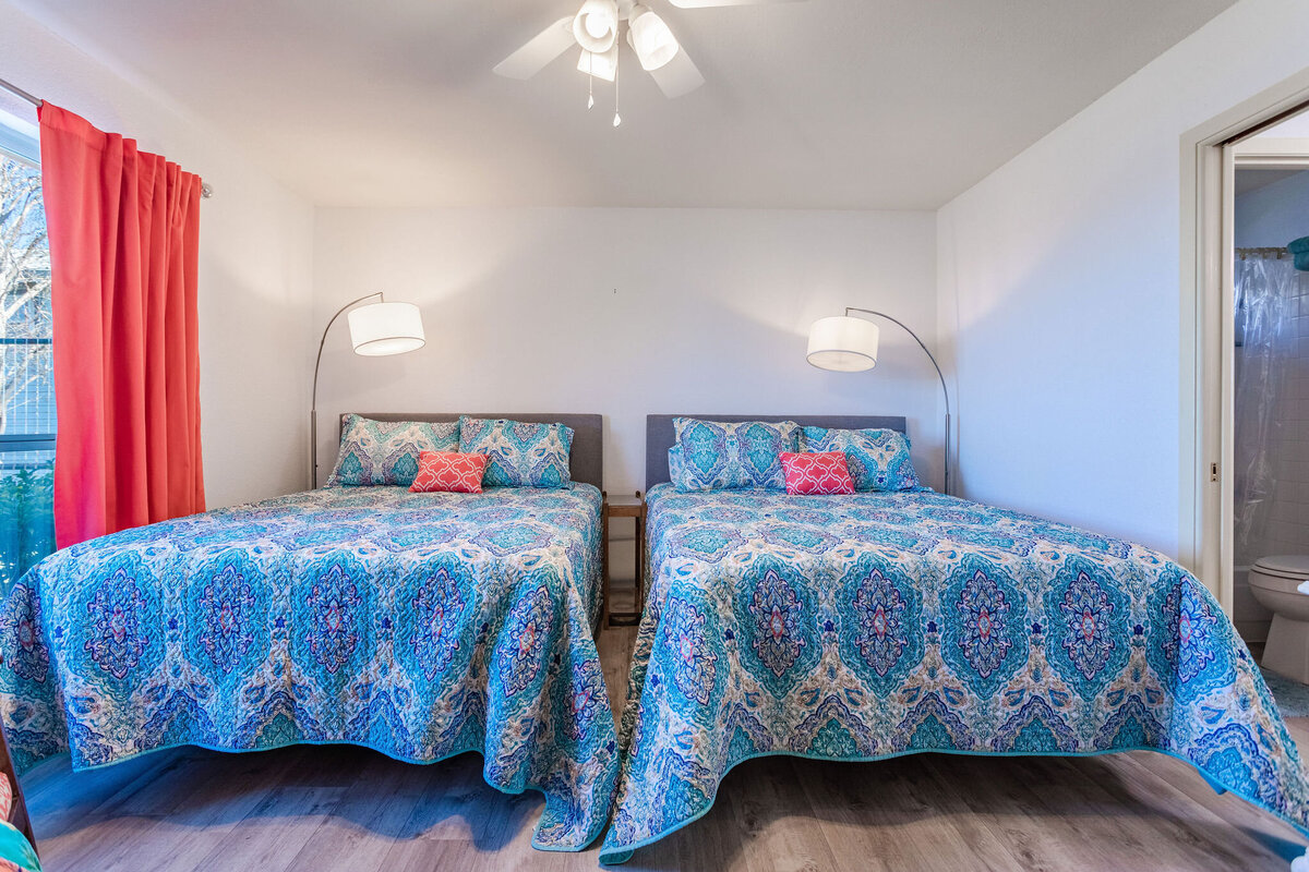 Bedroom with comfortable bedding and room to sleep four in this 2-bedroom, 2-bathroom lakeside vacation rental home for 6 guests on Tradinghouse Lake with privacy access to a fishing dock and boat launch pad, ping pong table, gazebo, free wifi and free parking in Waco, TX.