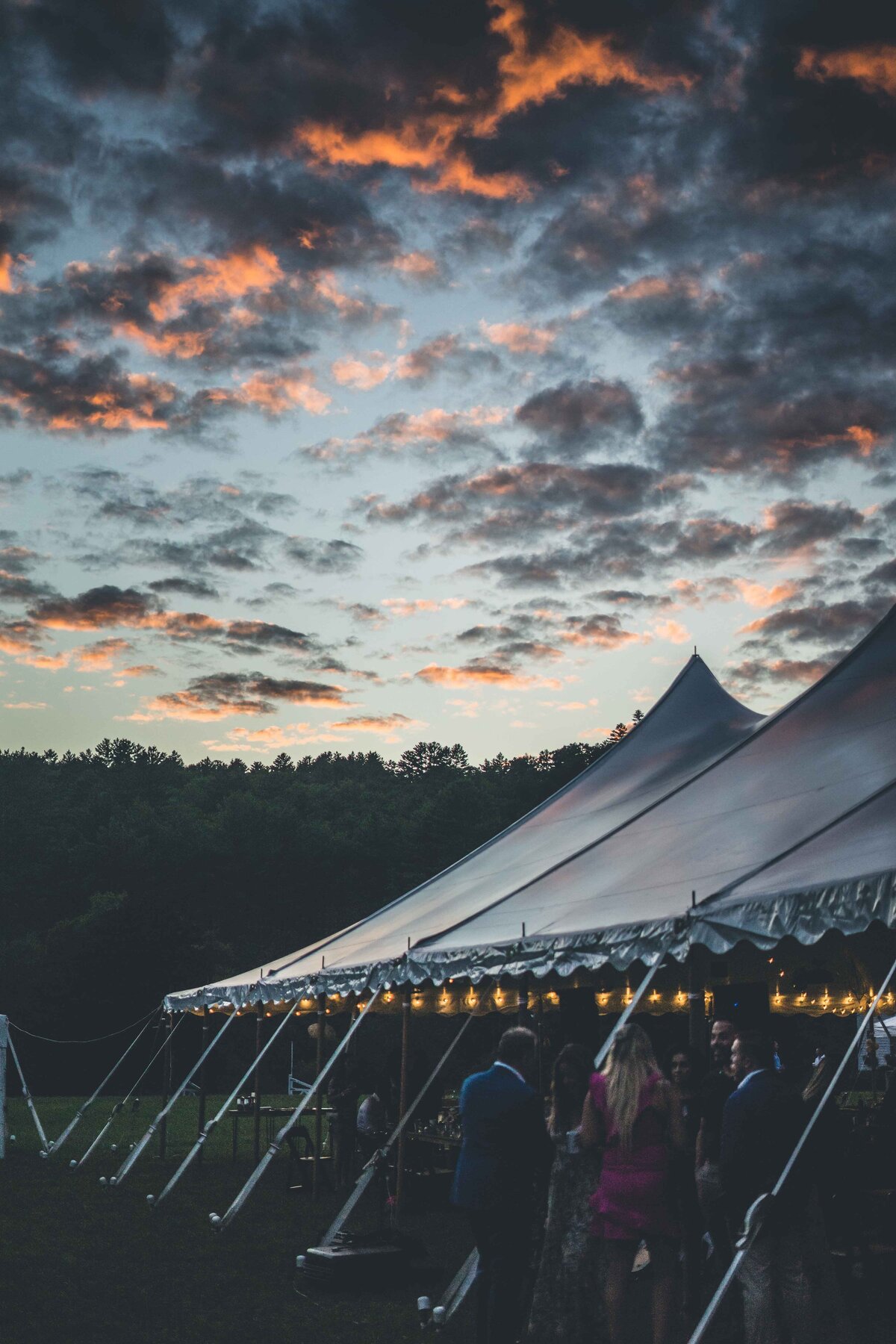 an outdoor wedding tent underneath a sunrise