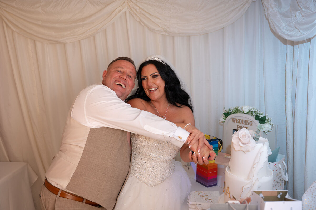 Bride and groom during first cake cut - candid reception - Heaton Park Weddings