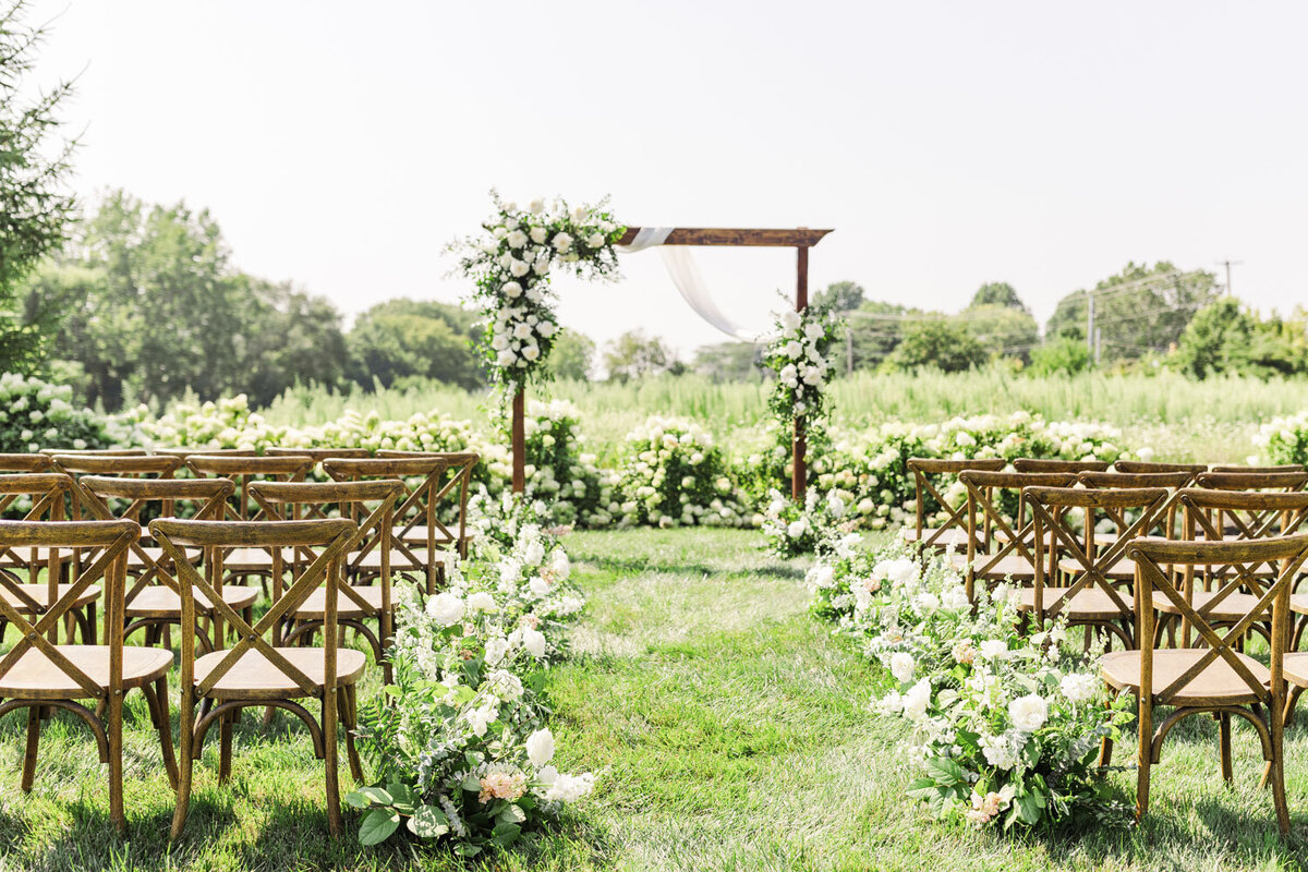 wooden altar decorated with white flowers and rows of brown wooden chairs
