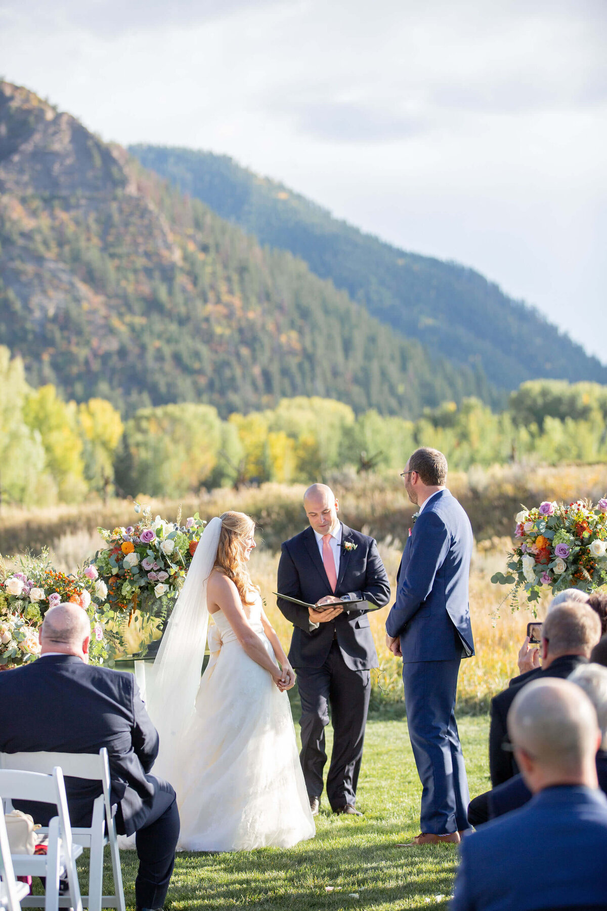 Bride and groom say vows with aspen mountains in the background