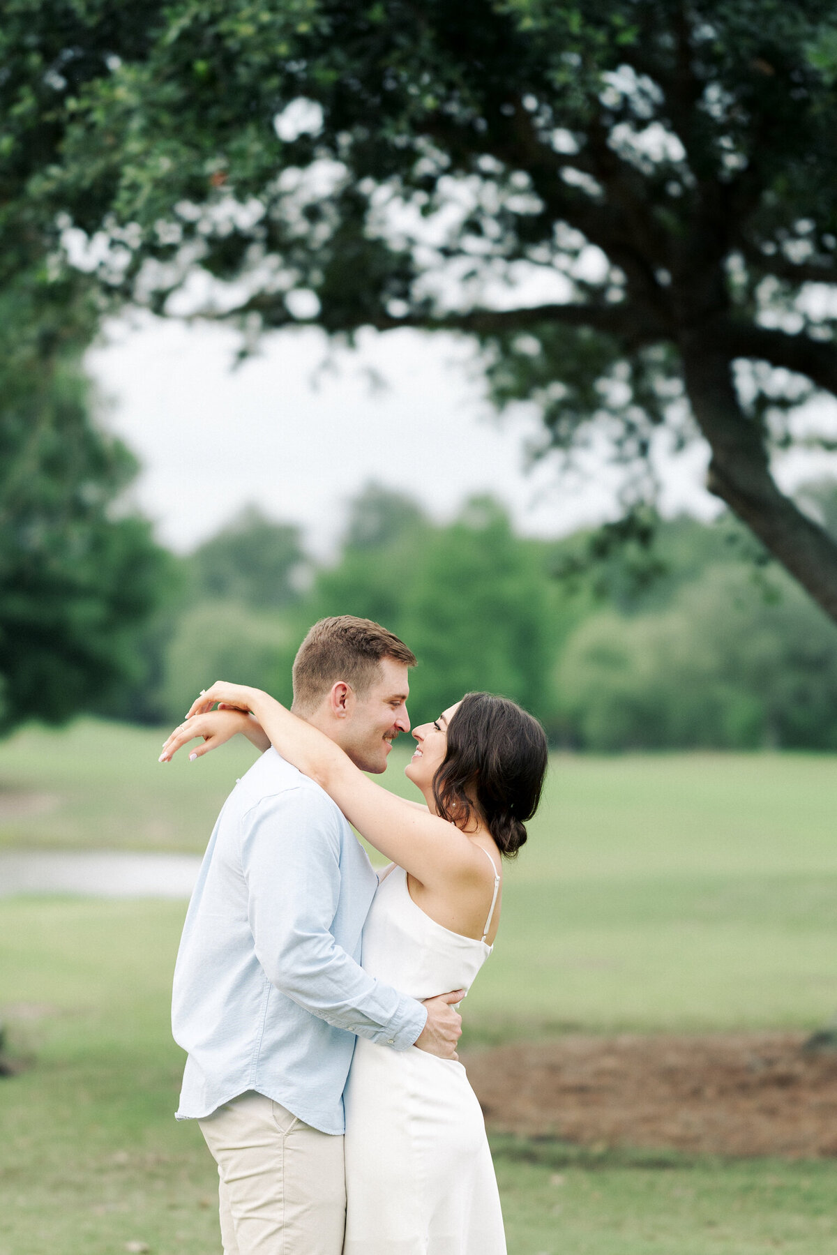 A picturesque engagement session set amidst the lush landscapes of Koasati Pines Golf Course, capturing love and elegance on film by Morgan Alysse, Louisiana film photographer.