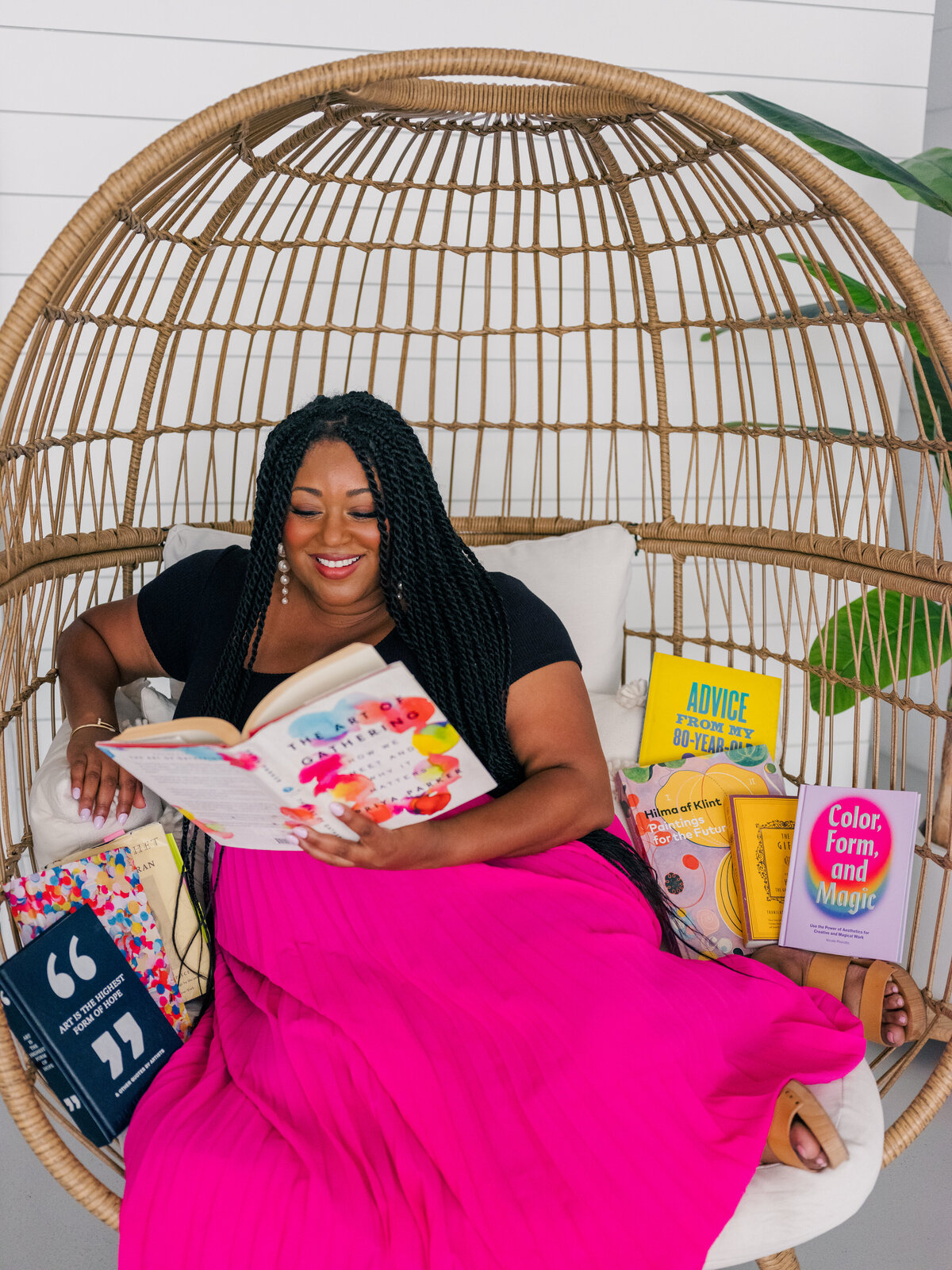 Woman business owner reading books in an egg chair