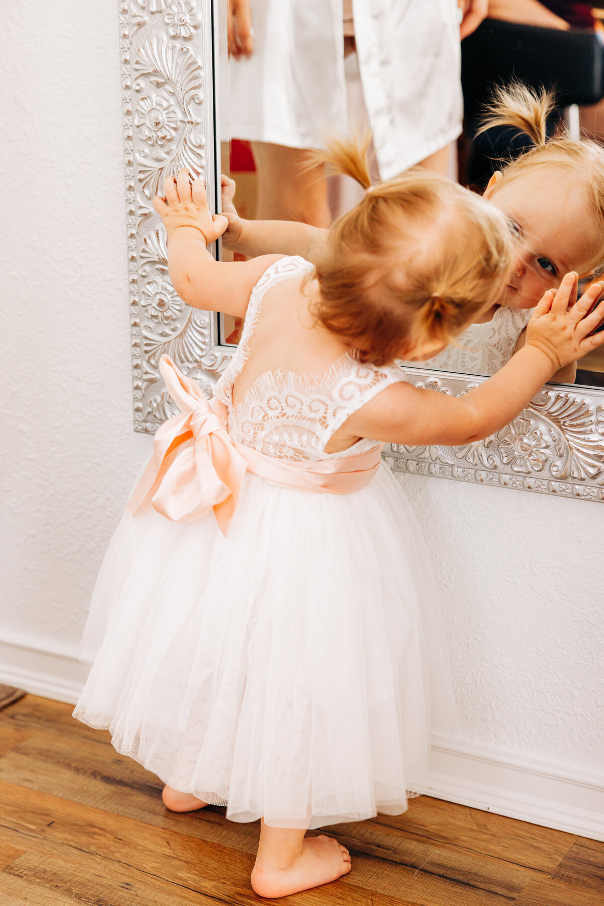 Baby flower girl looking in mirror at Flathead Lake Forevers in Big Arm, MT