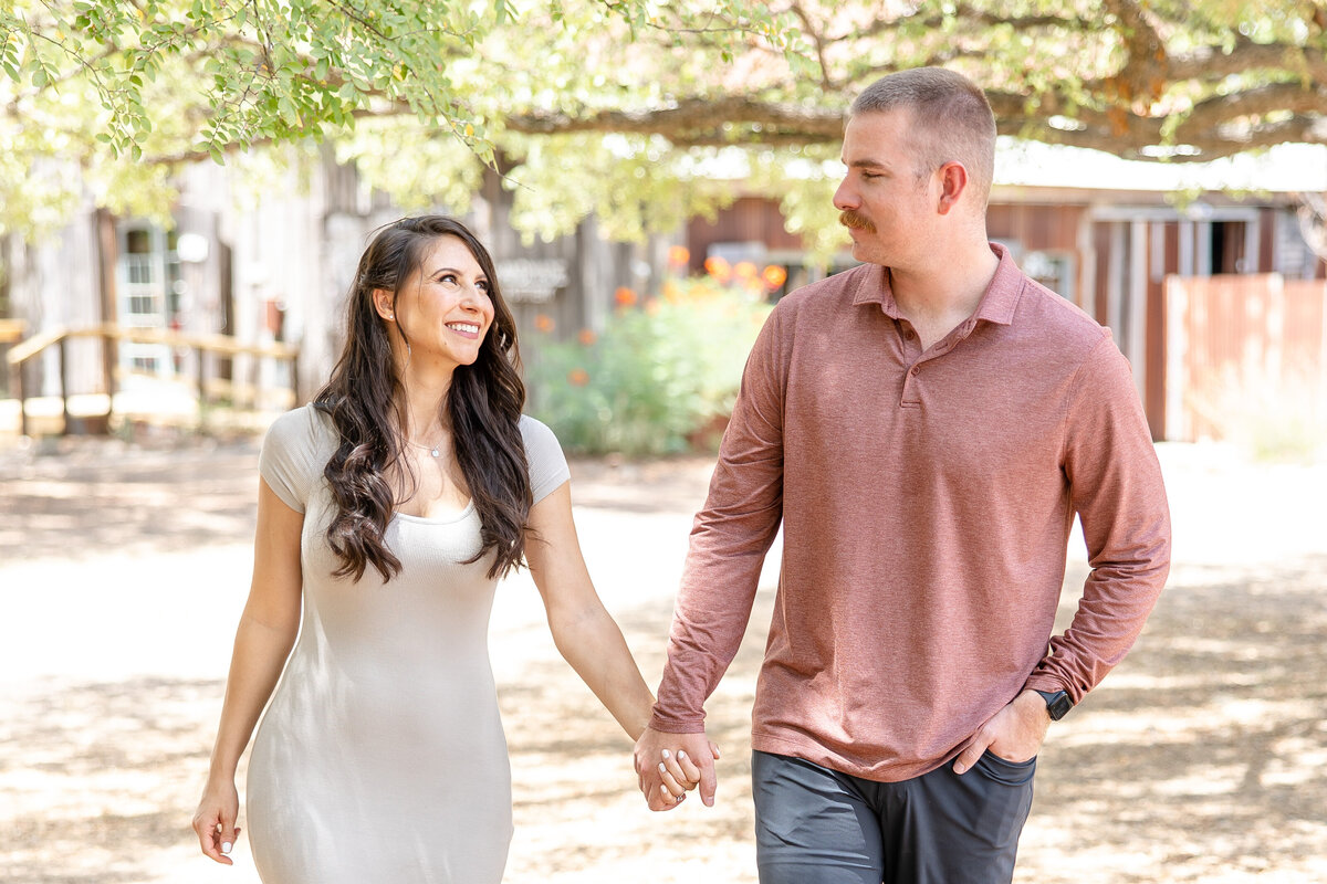 long brown hair bride with fiance walk through Gruene in New Braunfels Texas before wedding by Firefly Photography