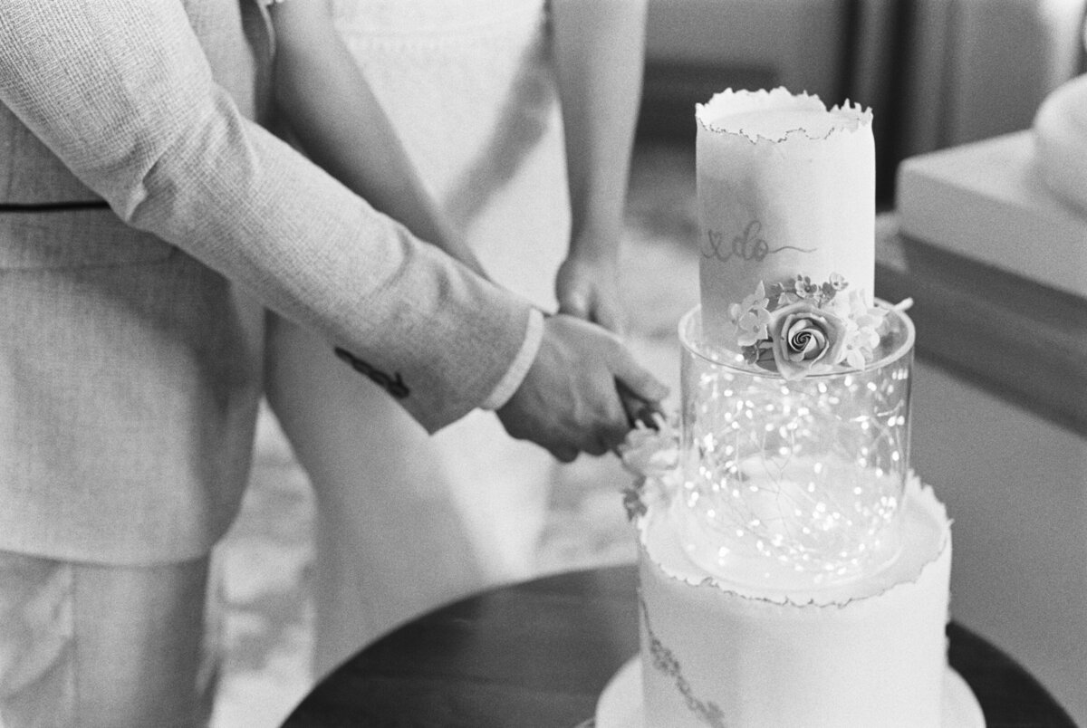 close up of bride and groom cutting two tier wedding cake
