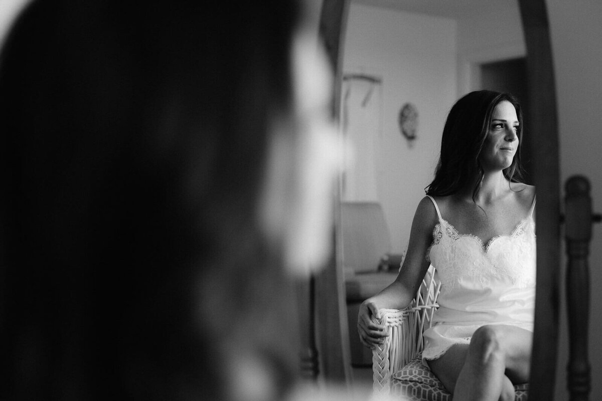 The bride's reflection on a mirror while sitting down inside a room at Wianno Club, Cape Cod, MA.