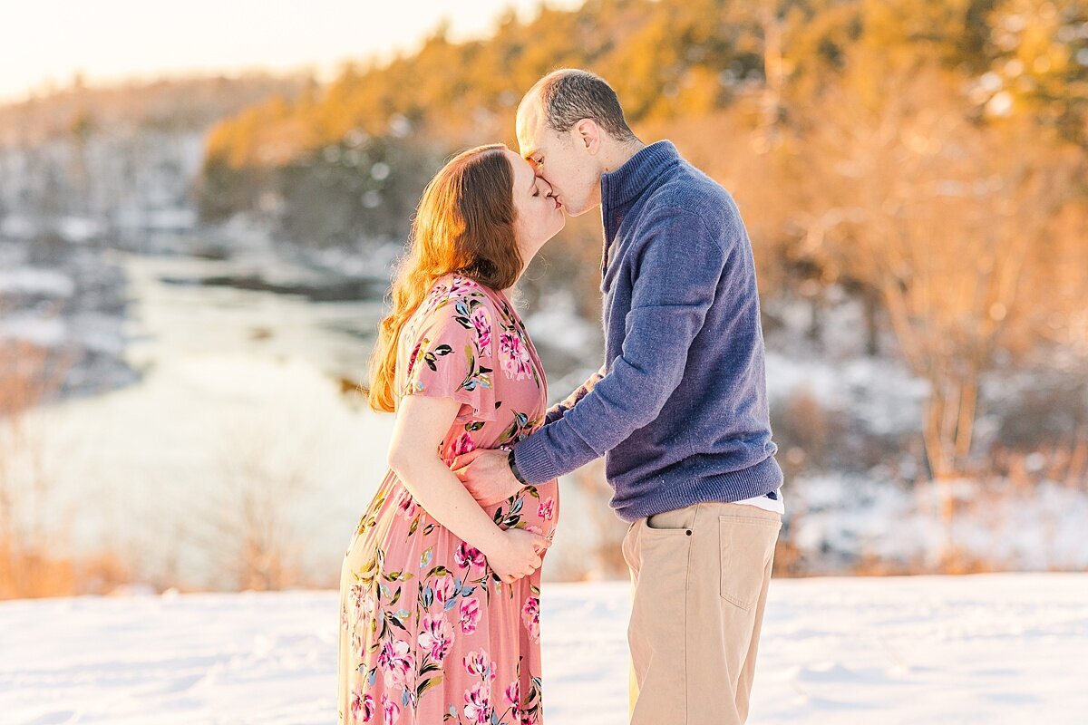 couple kisses during winter maternity photo session with Sara Sniderman Photography In Natick Massachusetts