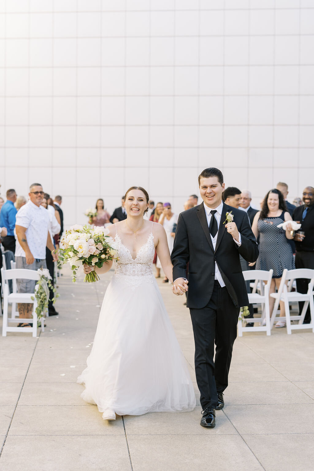bride and groom walking down aisle smiling