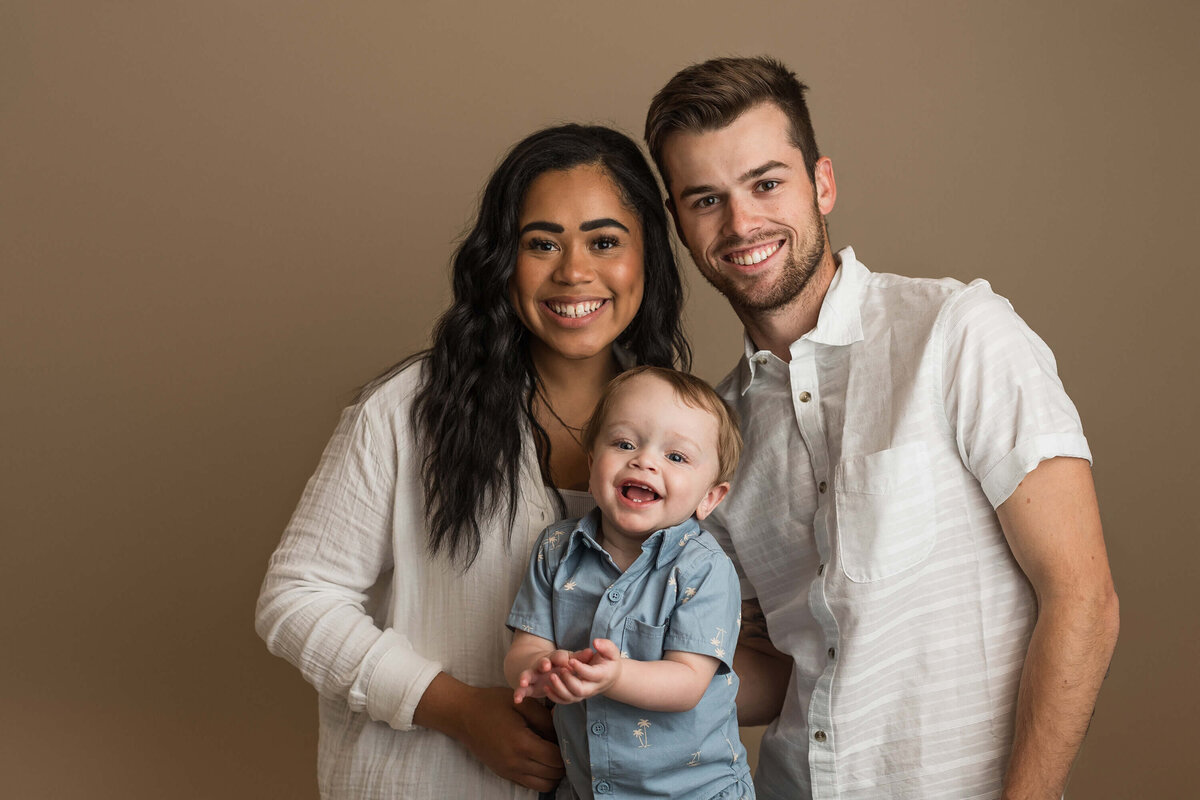 A beautiful mom and dad pose with their little boy during his one year portrait session.