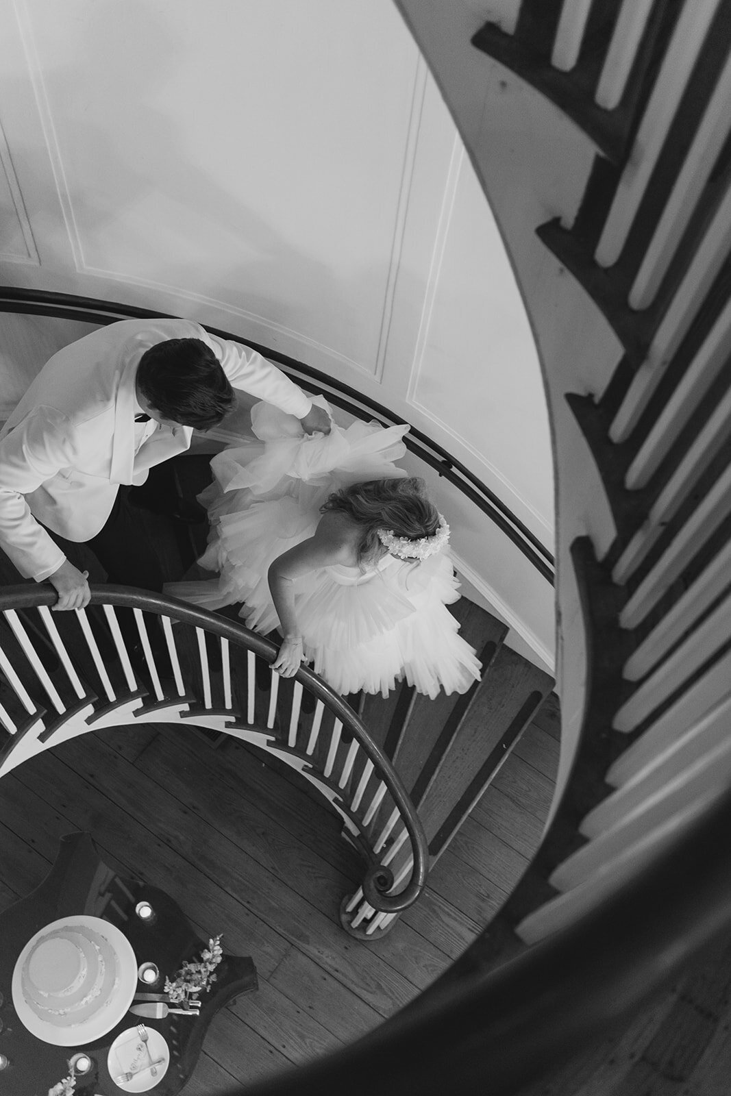 Groom helps bride with dress down the curved steps at Lowndes Grove. Kailee DiMeglio Photography.