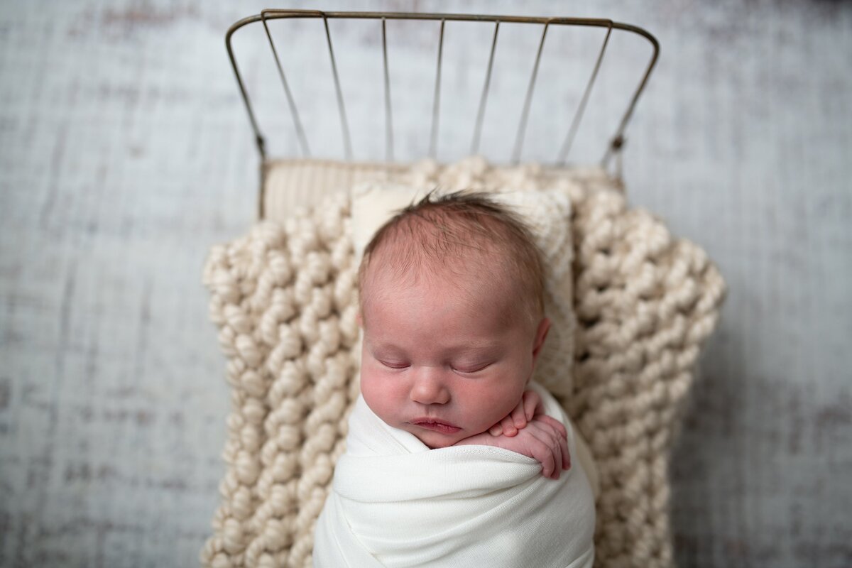newborn on bed with neutral colors