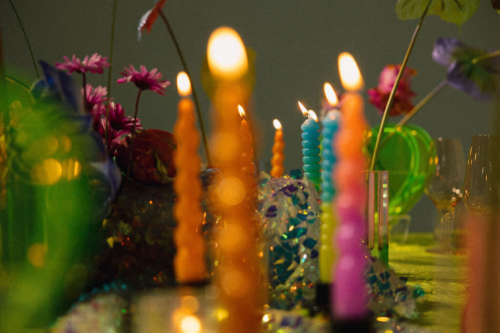 Colorful candles lit on a table.