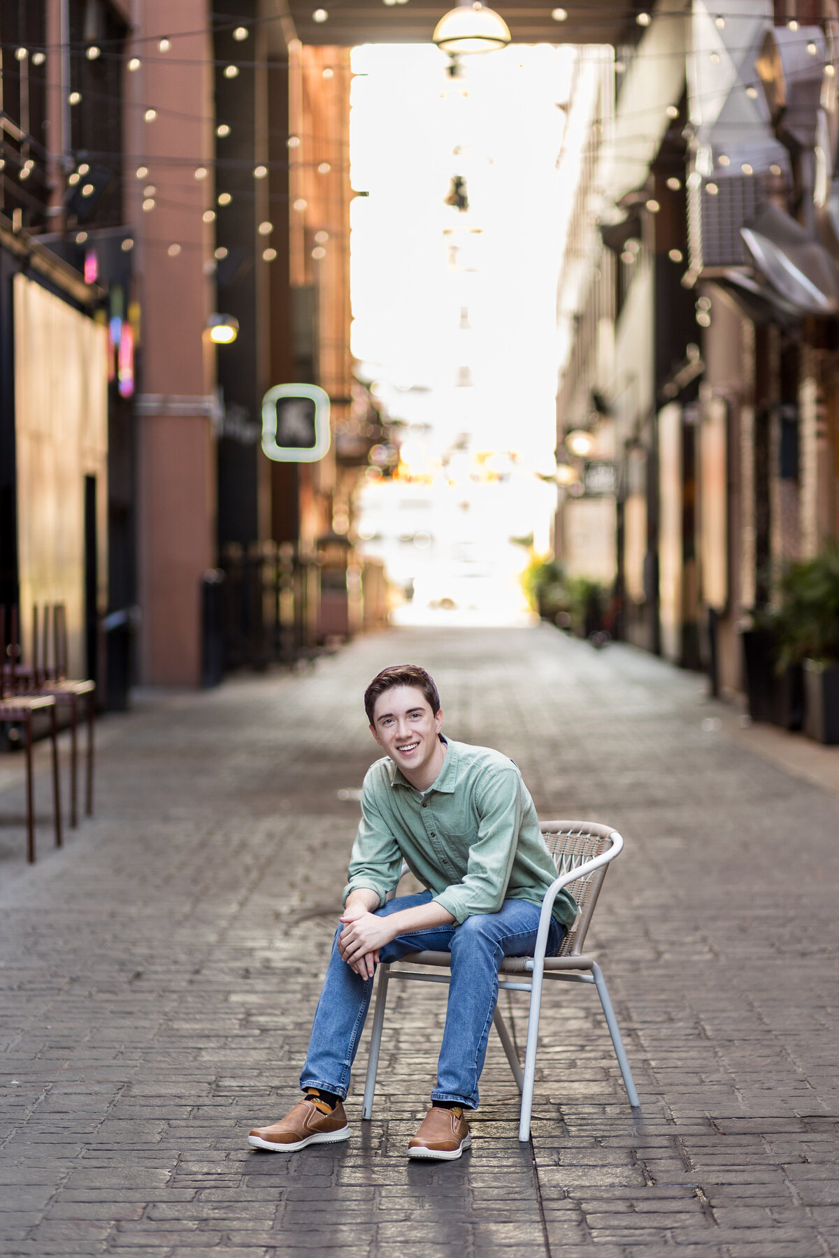 Boy in chair posing for downtown Detroit senior photographer Savvy Shoots Photography