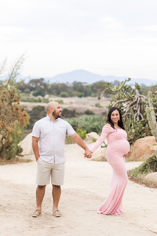 man and pregnant wife standing in balboa park cactus garden