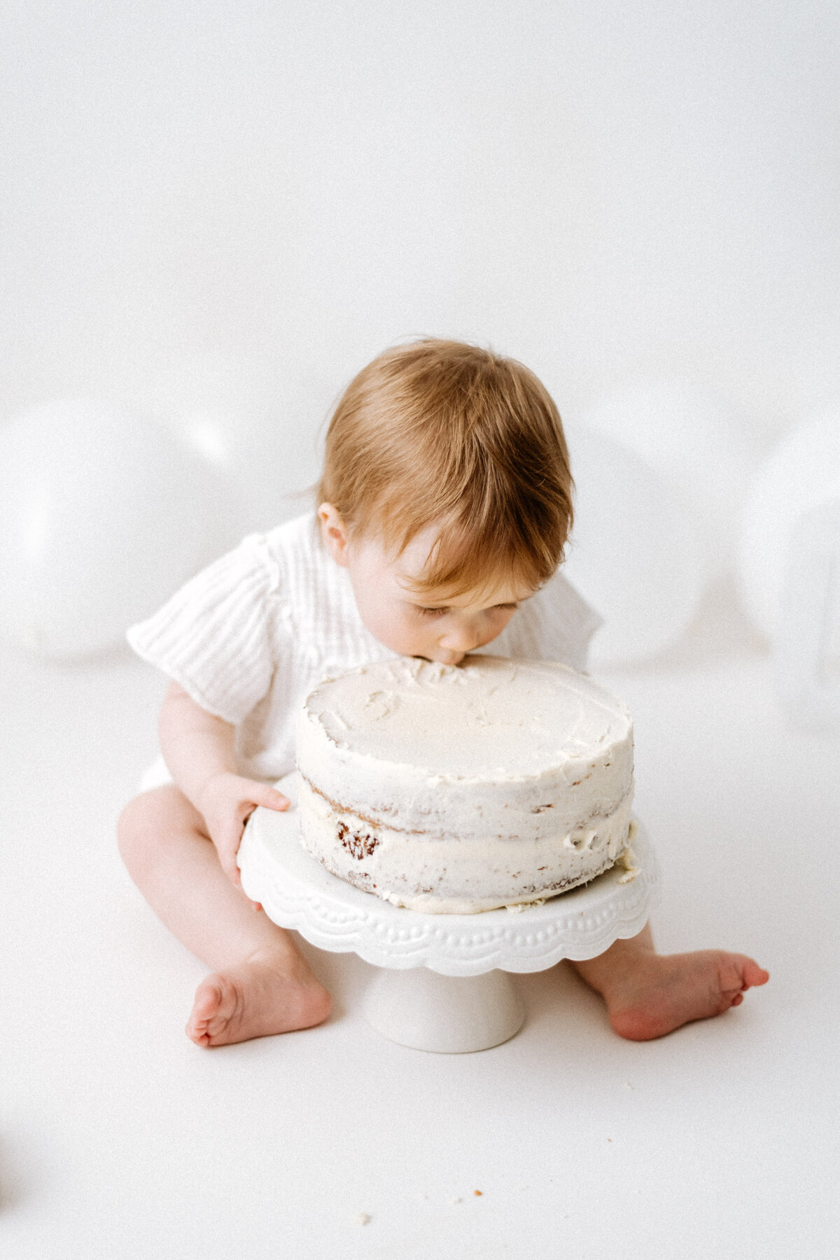 Baby eating a cake in cake smash photoshoot in billingshurst