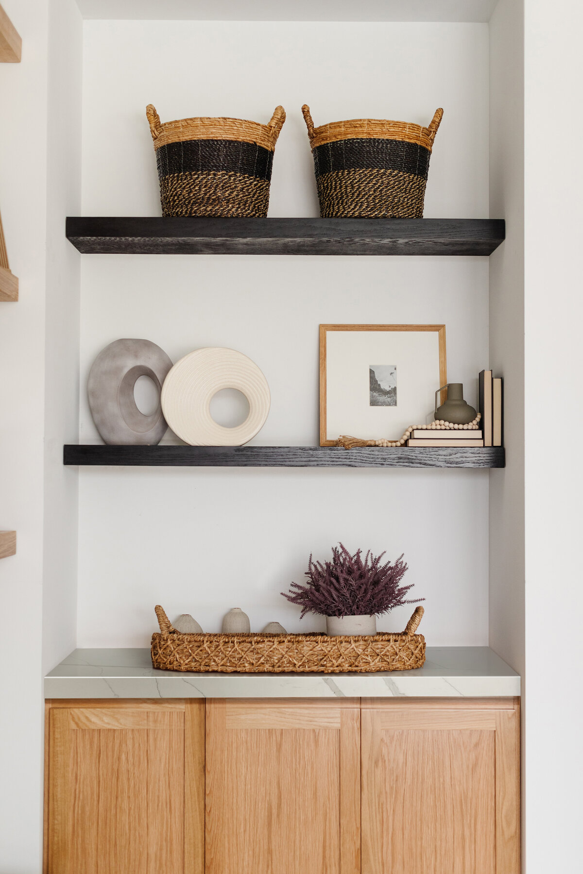 Wicker baskets and accents on dark wood shelves