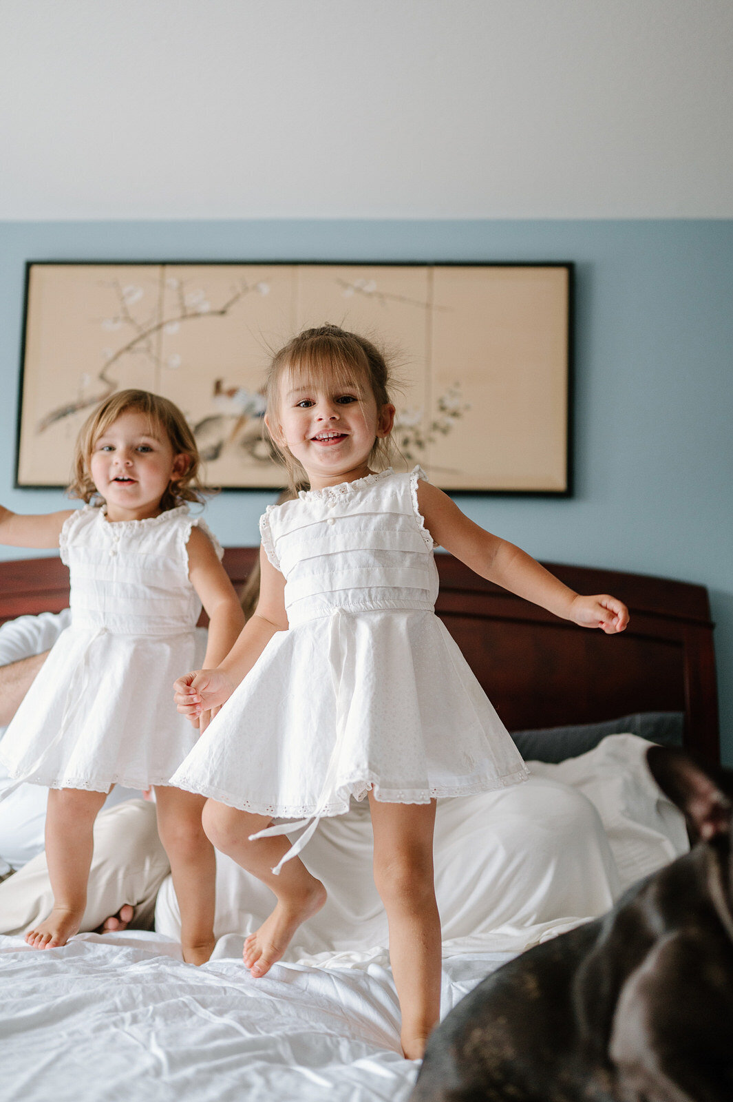 Twins jumping on bed in joy