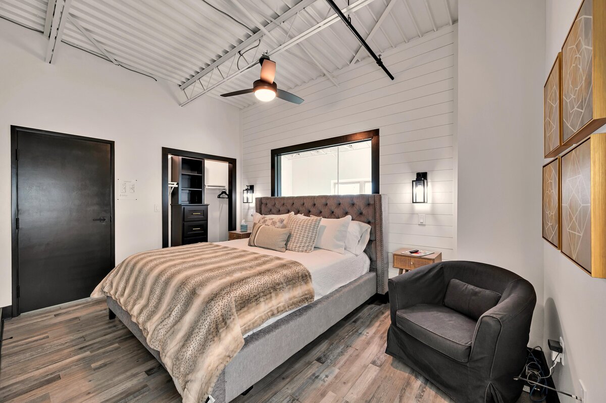Comfortable bedroom in this two-bedroom, three-bathroom top floor corner loft in the historic Behrens building in downtown Waco, TX