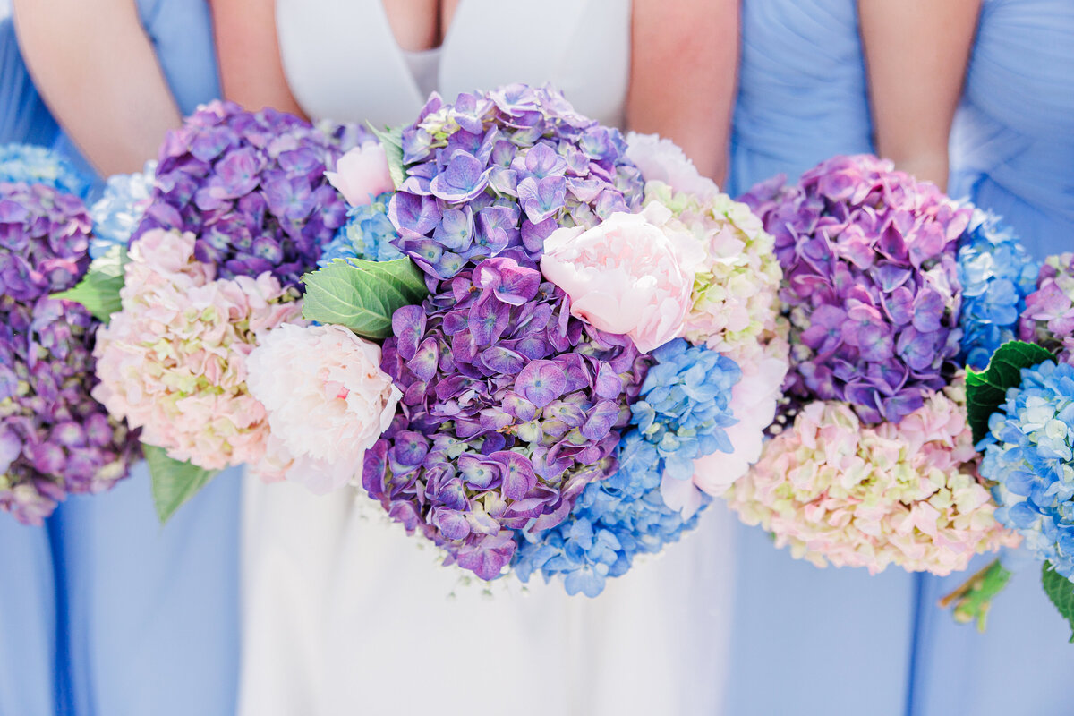 Close up of bride and bridesmaids holding bouquets representing Cape Cod wedding florals