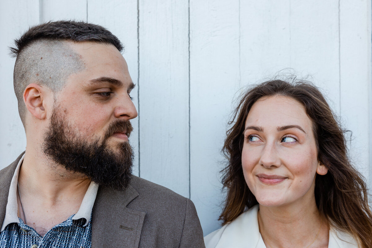 A couple looks at each other during an engagement photo shoot.