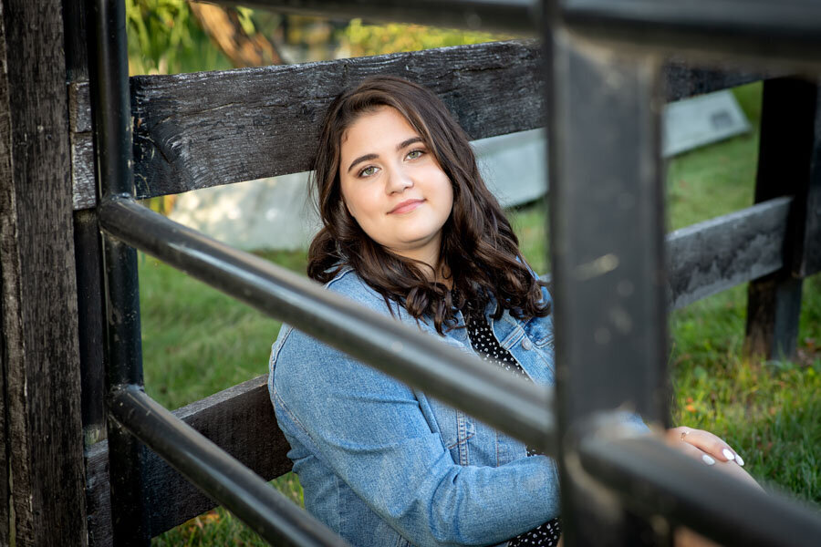 senior girl framed with fence section