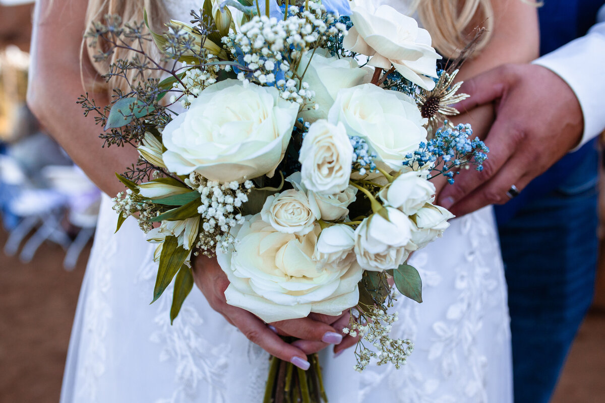 Stunning close-up shot of a bride holding an elegant wedding bouquet. The floral arrangement features a mix of white roses, greenery, and delicate accents, capturing the beauty and detail of a perfect wedding day in Salem, Oregon.