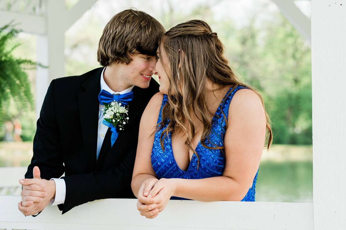 Man in suit and woman in blue dress looking at each other