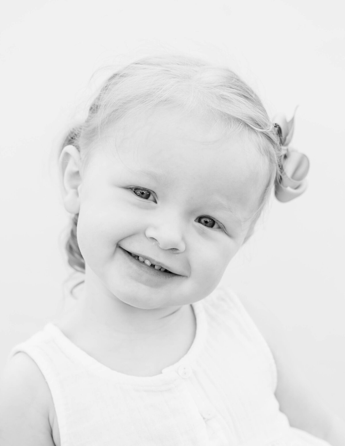 Toddler girl laughing naturally on white backdrop — S. Reed Photography school portrait