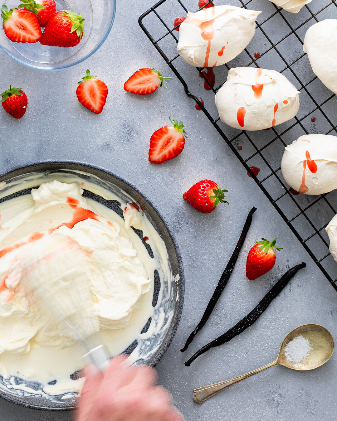 Meringues on a tray with whipped cream and strawberries