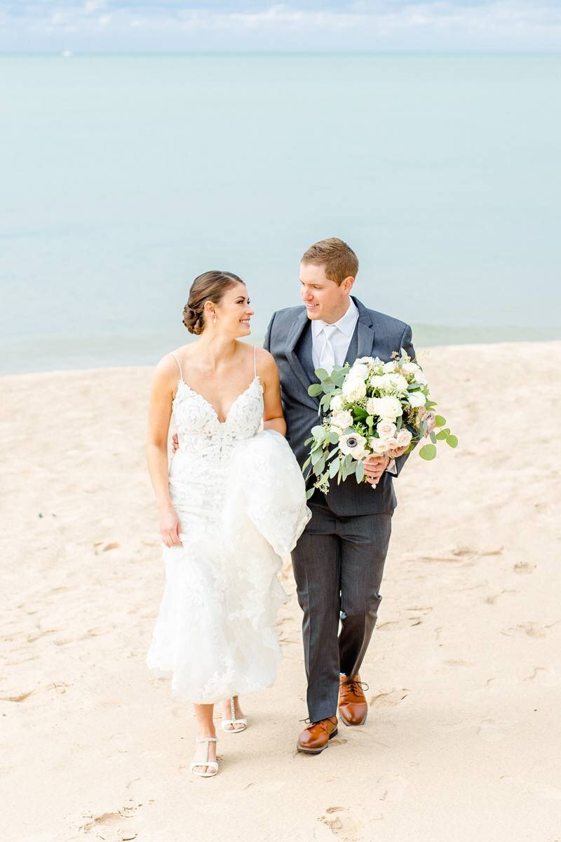 classic photo of bride and groom walking on beach