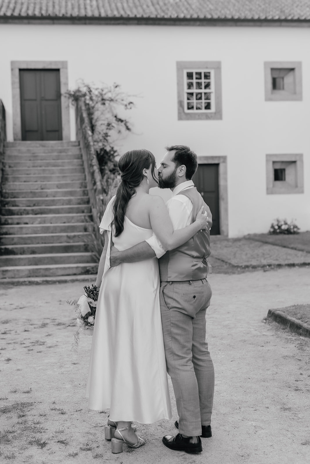 Bride and Groom softly kiss with arm round each others waist