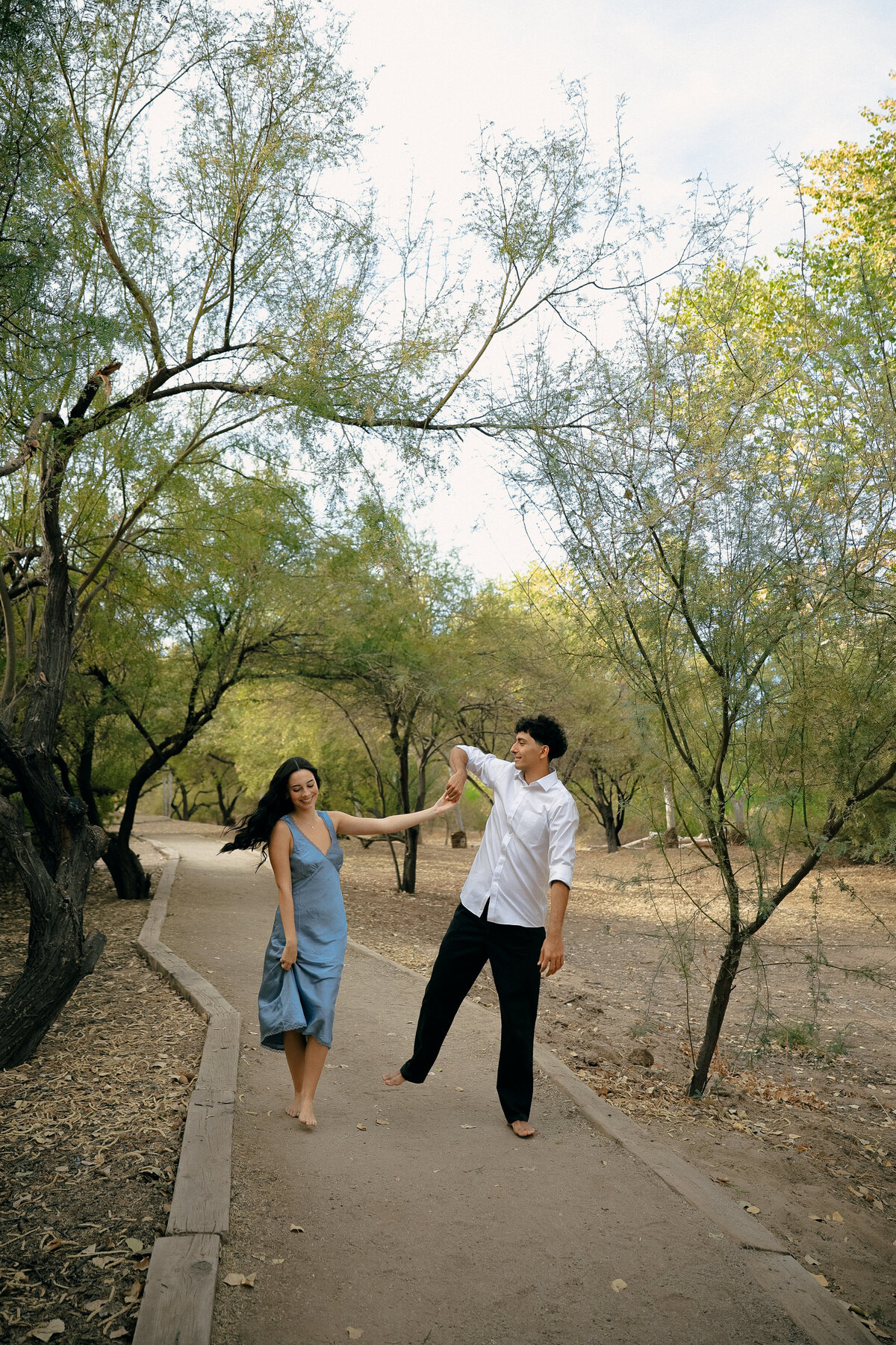Joyful Couple Dancing Barefoot Under the Trees During Oregon Engagement Session