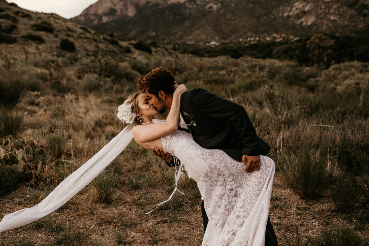 groom dipping and kissing bride in Albuquerque desert