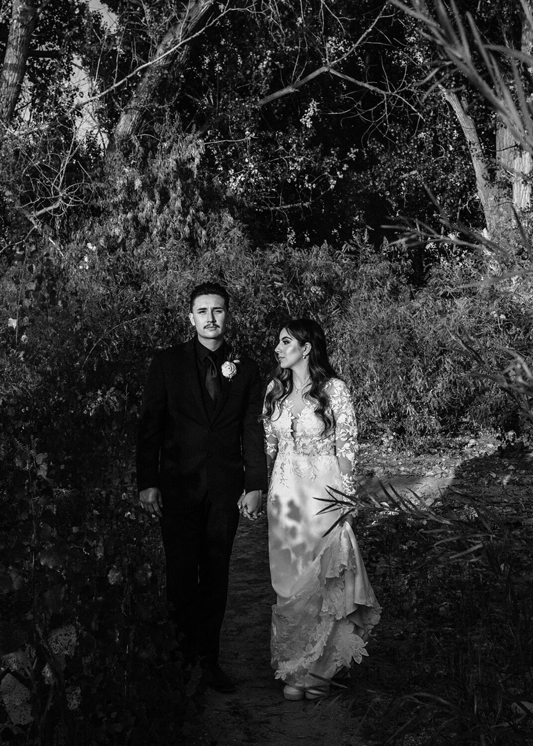 Black and white photo of bride and groom while walking