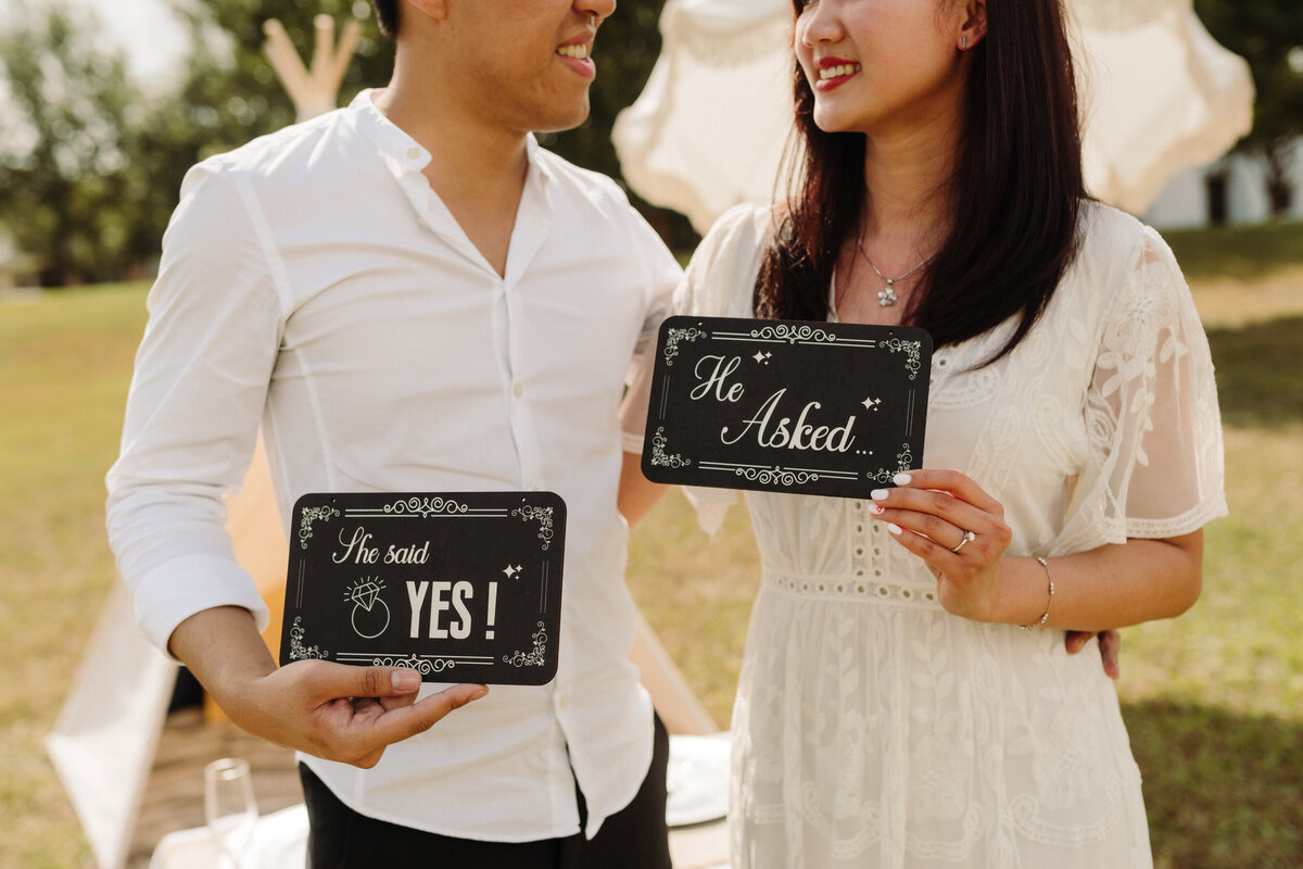 Unique proposal ideas couple holding engagement signs